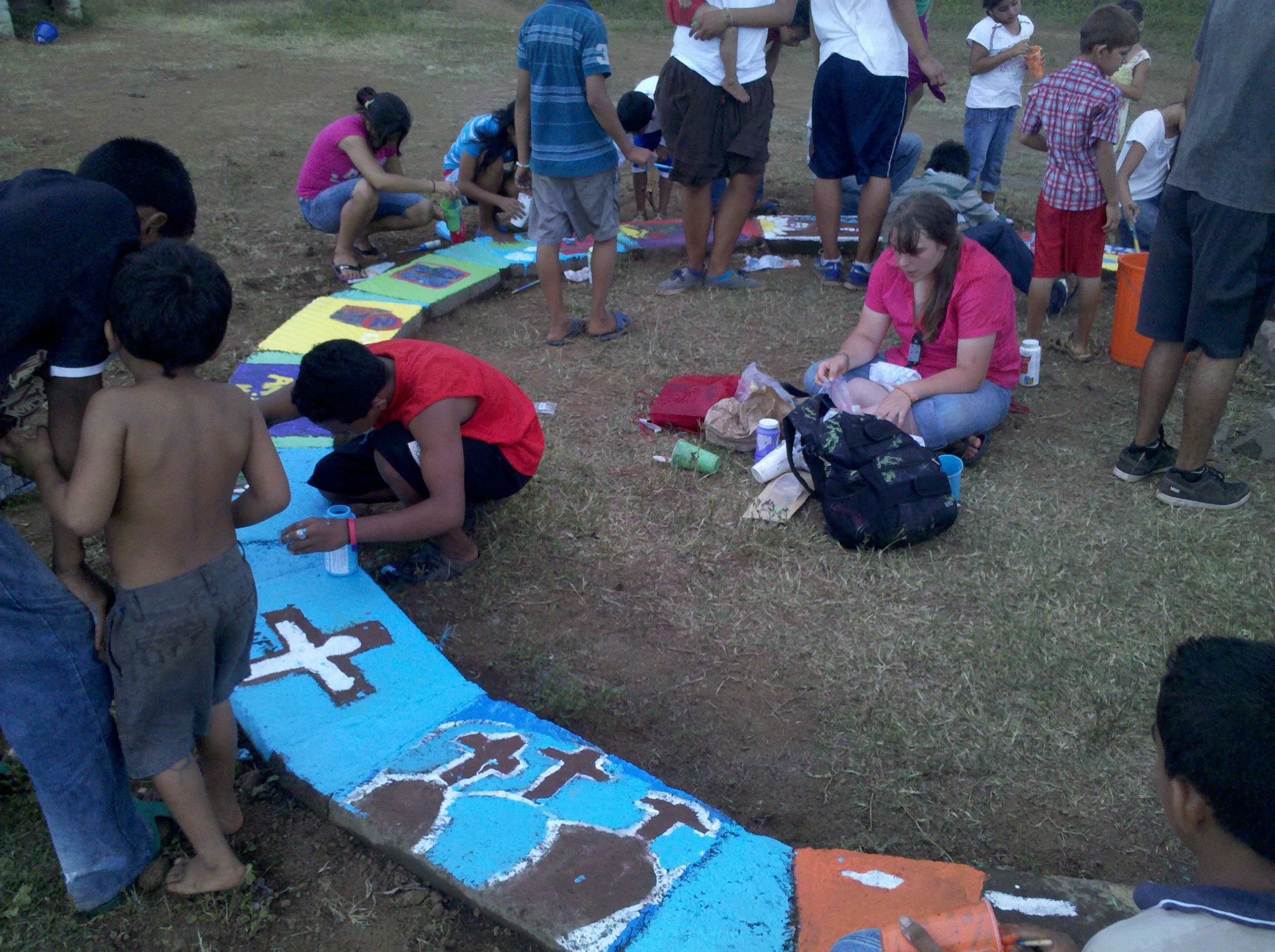 Children painting the finished construction project at the center of Barrio Nuevo.